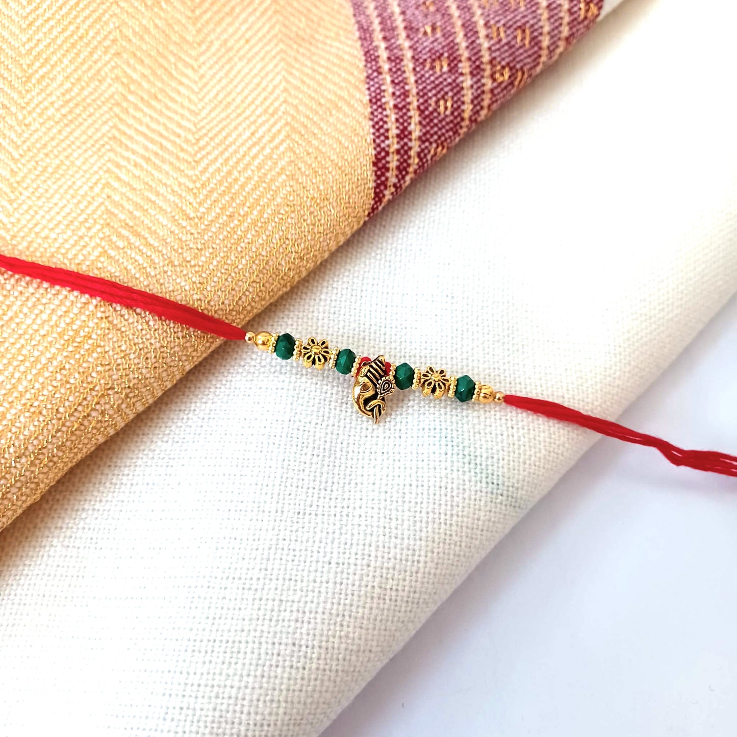 Floral Gold Rakhi On A Red Thread