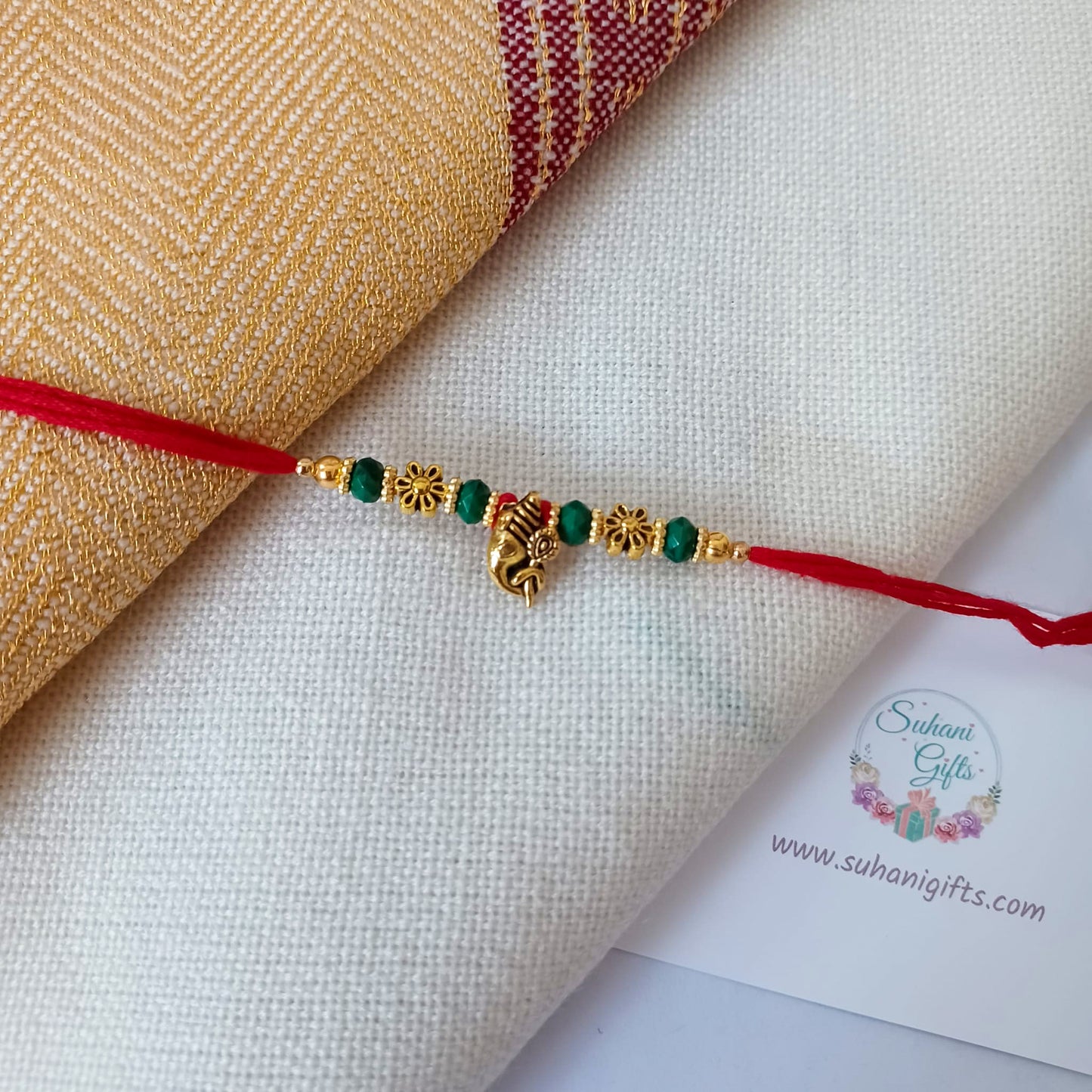 Floral Gold Rakhi On A Red  Thread